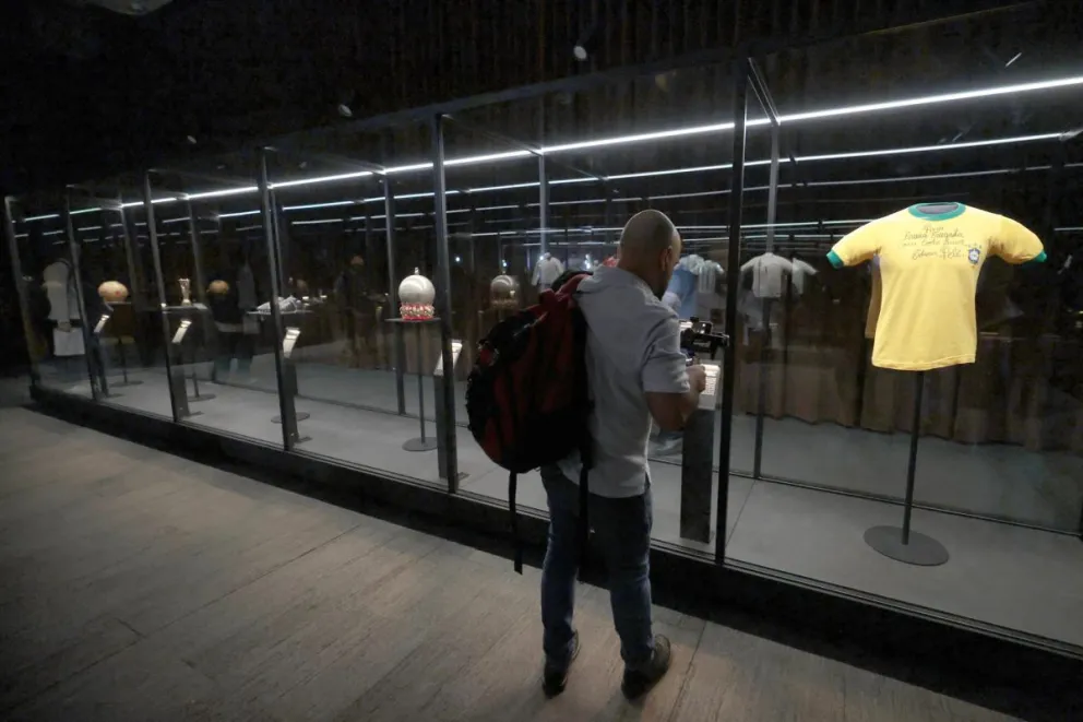 Una persona recorre la exposición 'Objetos de leyenda: momentos icónicos en la historia del fútbol'. Foto: EFE.