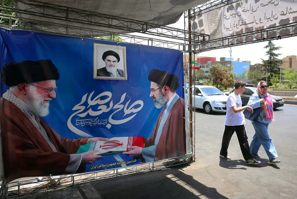 Iraníes pasan junto a un cartel del difunto líder supremo iraní Alí Jameneí (I) junto a su hijo y sucesor, Mojtaba Jameneí, en Teherán. Foto: EFE