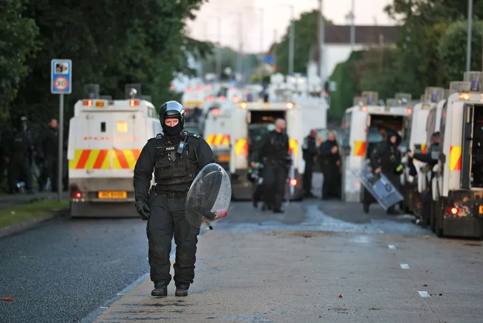 Un agente de policía camina con equipo antidisturbios en el lugar de los disturbios antiinmigración en Antrim Road en Newtownabbey, al norte de Belfast, Irlanda del Norte. Foto: EFE