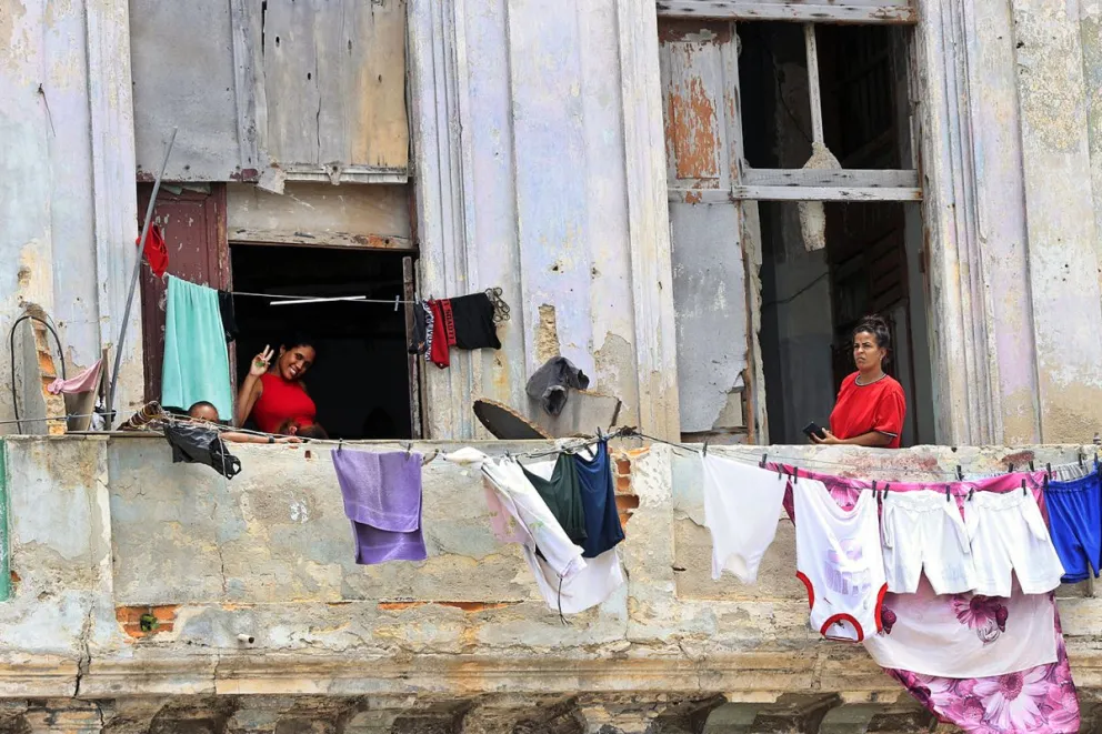 Un par de mujeres y un niño fueron captados este 12 de junio en las ventanas de un inquilinato en el centro de La Habana. Foto: EFE