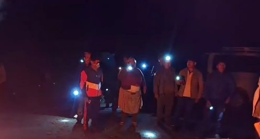 Un grupo de personas con linternas alrededor de una fogata, quienes se identificaron como integrantes de la Federación Intercultural de Chimoré. Foto: Captura