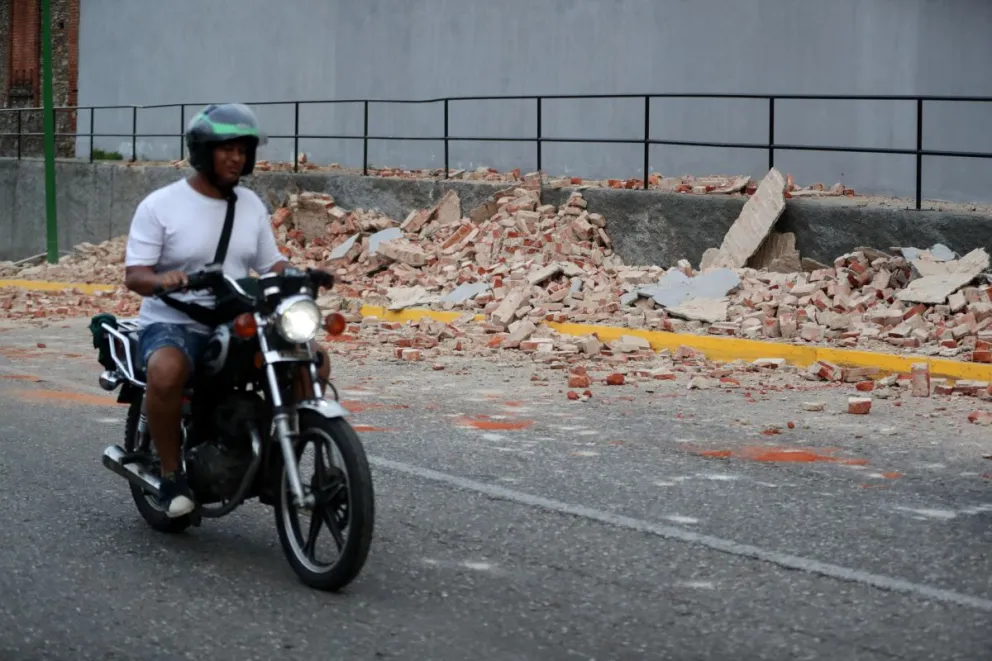 Un motociclista transita cerca de escombros este miércoles, en Caracas (Venezuela). EFE