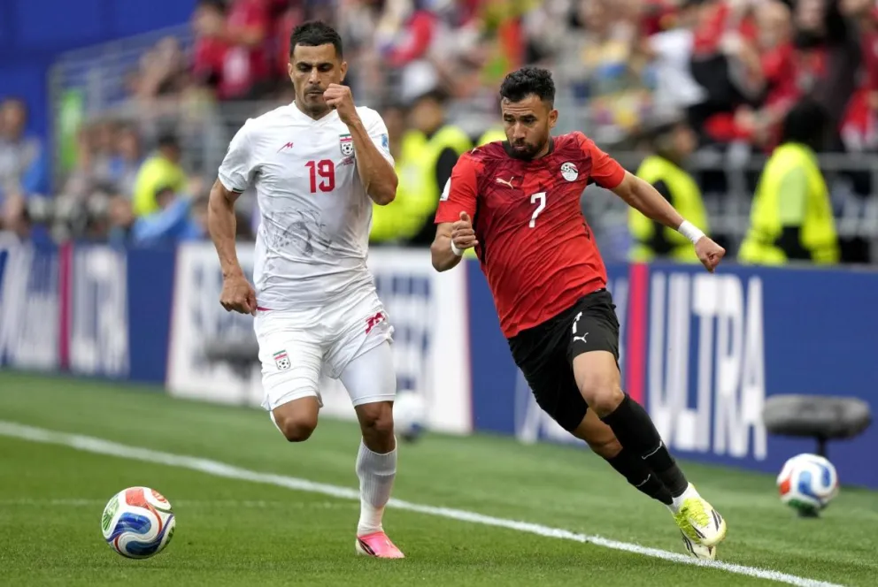 Trezeguet (der.), de Egipto, trata de superar en velocidad a Ali Nemati, de Irán, en el cotejo depo rle Grupo G. Foto: EFE