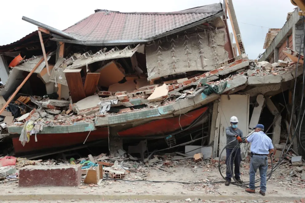 Hombres trabajan este sábado, frente a una casa derrumbada por los terremotos en Venezuela, en El Junquito (Venezuela). Foto: EFE