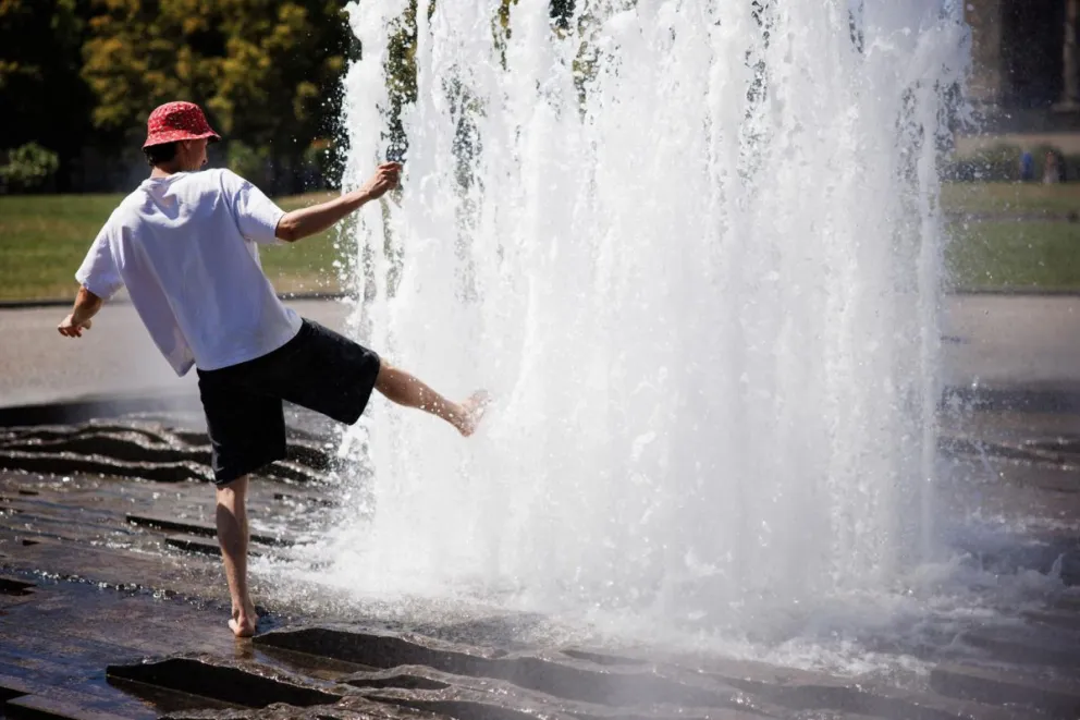 Un hombre tratando de refrescarse en Berlín. Foto: EFE