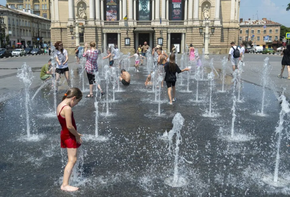 Un grupo de personas se refresca del calor provocado por las altas temperaturas en la ciudad ucraniana de Leópolis. EFE
