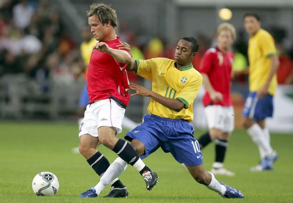 Fotografía de archivo del 16 de agosto de 2006 en la que se observa al brasileño Robinho (d) al luchar por el balón con el noruego Kristofer Haestad. Foto: EFE