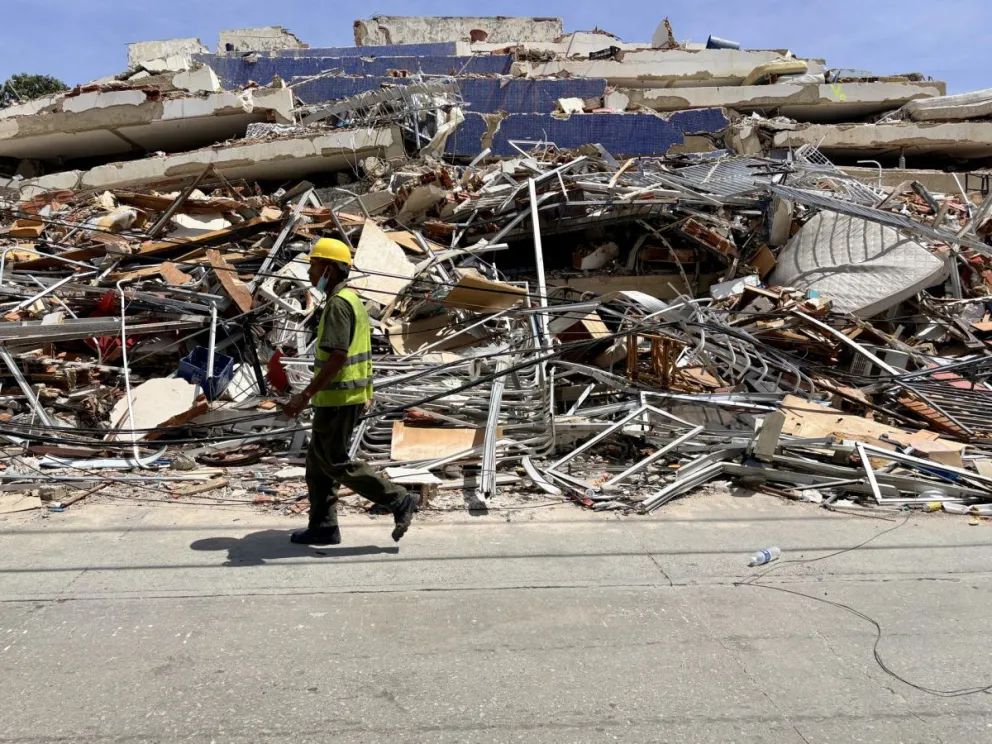 Un hombre camina frente a escombros de una edificación derrumbada por terremotos este jueves, en La Guaira (Venezuela). Foto: EFE/