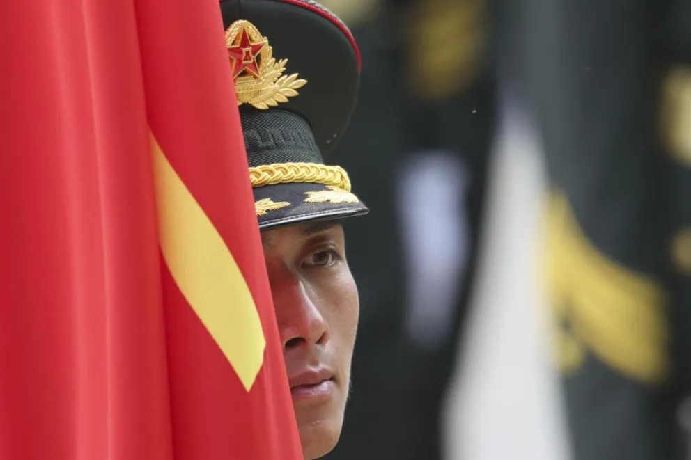 Un soldado chino junto a la bandera del gigante asiático. Foto: EFE 