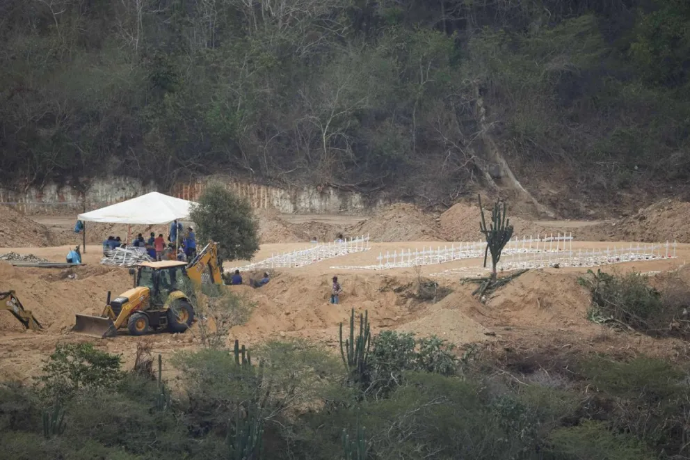 Fotografía que muestra a personas haciendo labores de excavación en el cementerio municipal La Esperanza este lunes, en Carayaca (Venezuela). EFE