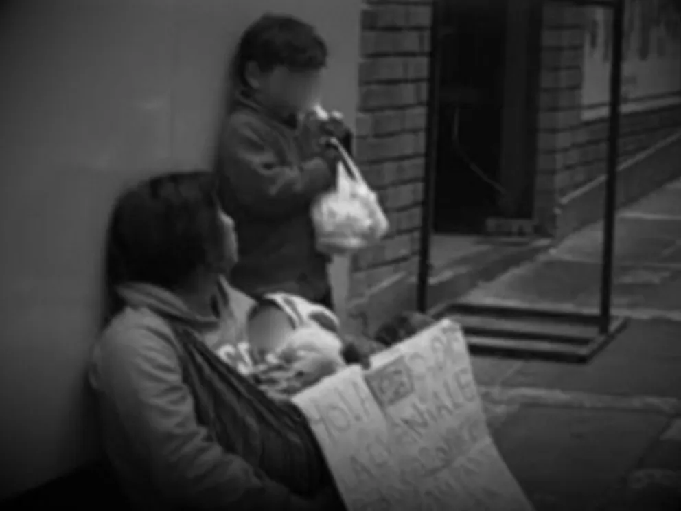 Una mujer con dos menores en la calle pidiendo limosna. Foto: ABI