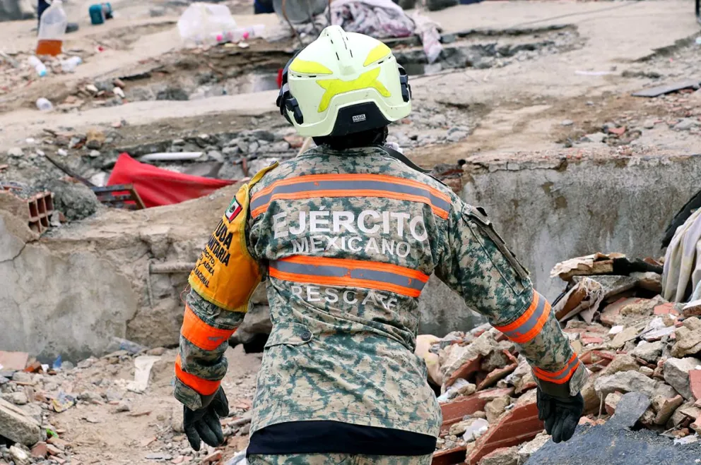 Una persona integrante del Ejercito de México realiza labores de búsqueda en los escombros de un edificio tras el doble terremoto del 24 de junio en Venezuela en La Guaira. Foto: EFE