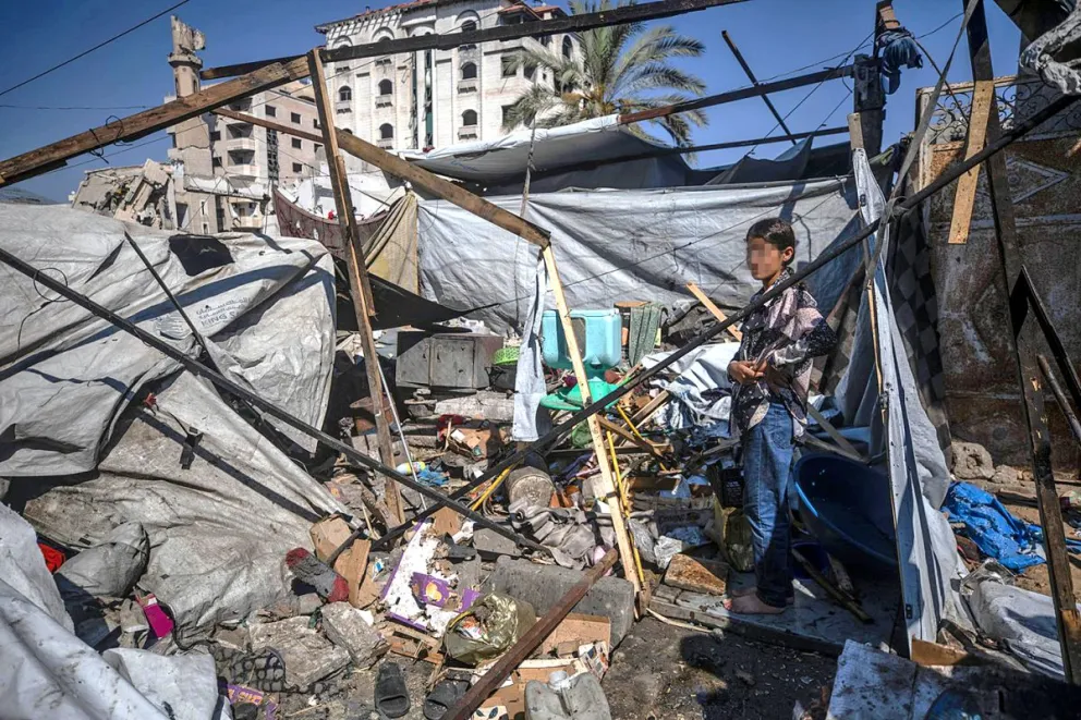 Una niña palestina inspecciona la tienda de campaña destruida de su familia en la calle Al Jalaa, tras un bombardeo israelí en la ciudad de Gaza, Franja de Gaza. Foto EFE