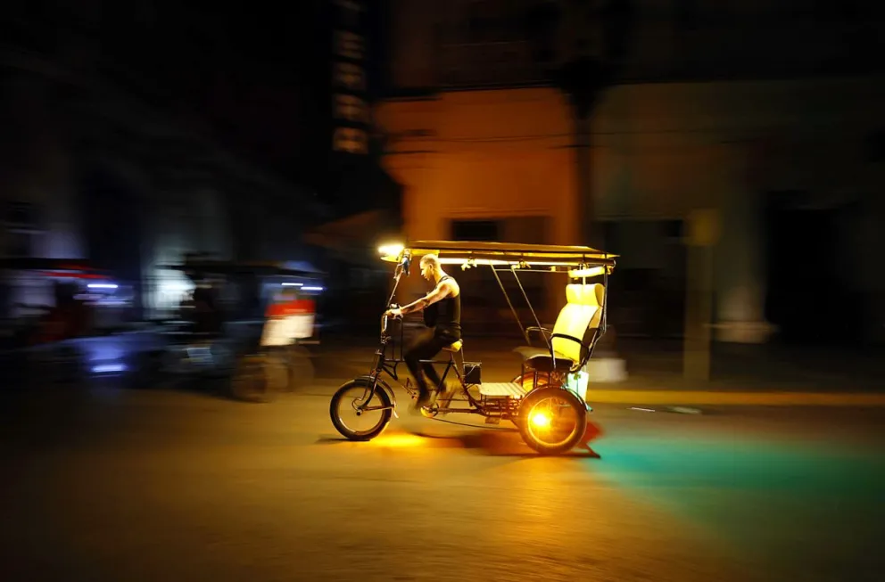 Fotografía de archivo de un hombre que conduce un bicitaxi durante un apagón, en La Habana (Cuba). Foto: EFE