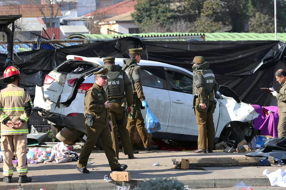Integrantes de Carabineros de Chile custodian el lugar en donde un cabo de la infantería de marina de Chile, que estaba fuera de servicio, embistió su vehículo contra una feria callejera. Foto: EFE