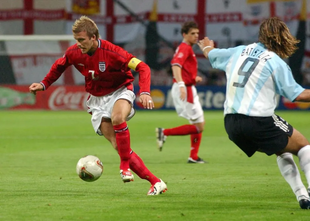 El inglés David Beckham (izq.) domina la pelota ante el argentino Gabriel Batistuta en el Mundial de 2002. Foto: EFE.