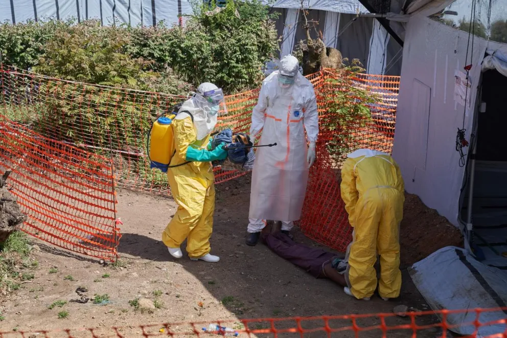 Personal médico desinfectando el cuerpo de un hombre infectado con ébola en el Hospital de Rwampara. Foto: EFE 