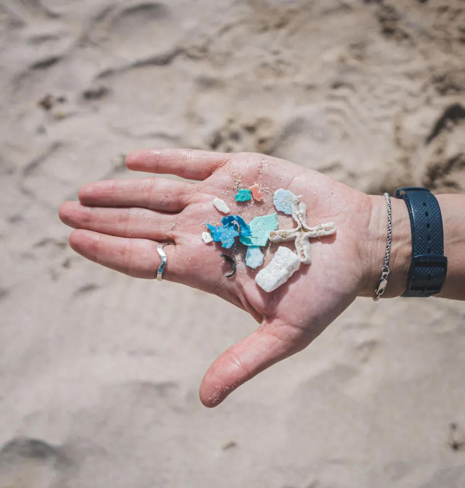 Una persona muestra trozos de microplástico durante la limpieza en una playa de Isla de Pascua (Chile), en una foto de archivo de 2023. EFE
