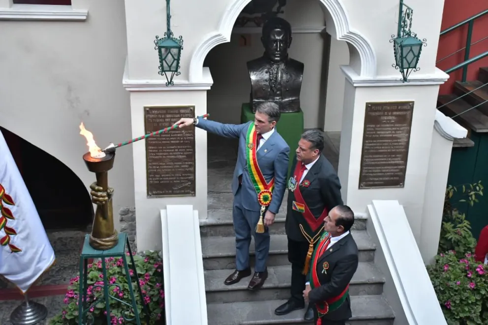 El presidente, Rodrigo Paz, enciende la tea en la casa del protomártir Pedro Domingo Murillo, junto al gobernador, Luis Revilla, y el alcalde, César Dockweiler. Foto: APG