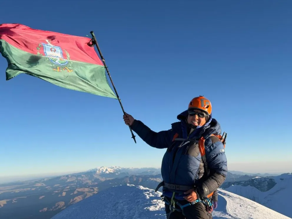 El andinista nacional en la cima del Illimani con la bandera de La Paz. Foto: Hugo Ayaviri.