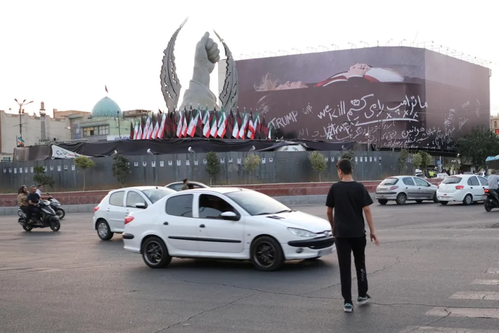 Un hombre cruza el paso peatonal a unos metros de un enorme mural sobre el presidente estadounidense Donald Trump. Foto: EFE 
