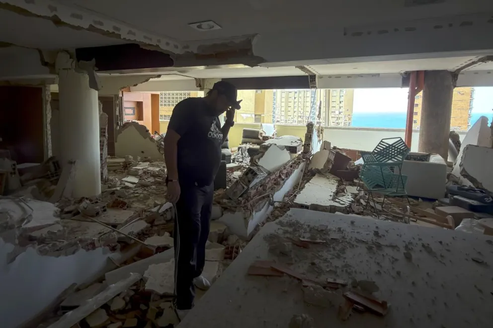 Una persona habla por teléfono en una edificación destruida por los terremotos del 24 de junio, este jueves en Catia La Mar (Venezuela). EFE