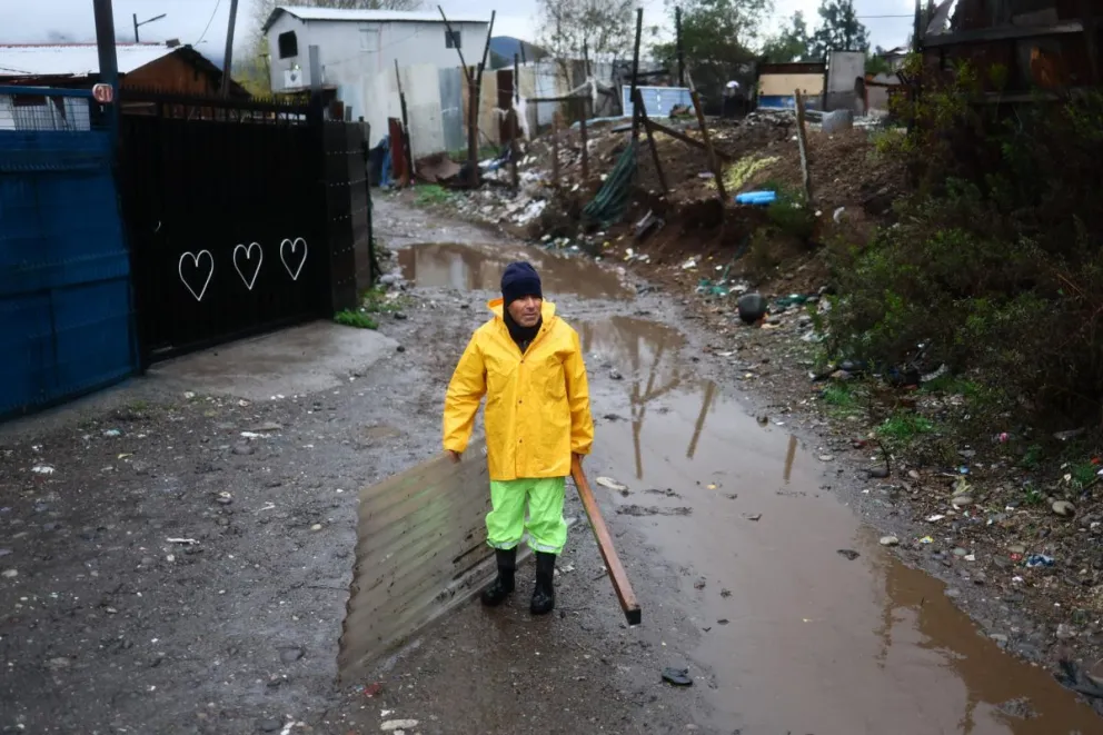 Una persona reacciona en un campamento que presenta riesgo de inundación por el temporal en la rivera del río Mapocho en Talagante (Chile). Foto: EFE