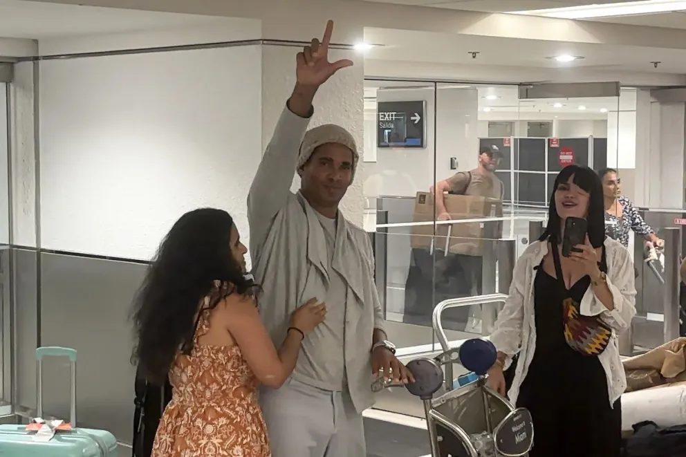 El artista plástico y opositor cubano Luis Manuel Otero Alcántara (c) saluda a su llegada este sábado a Miami, tras recuperar la libertad en la isla y recibir un amparo migratorio de Estados Unidos, después de cinco años encarcelado en Cuba. EFE