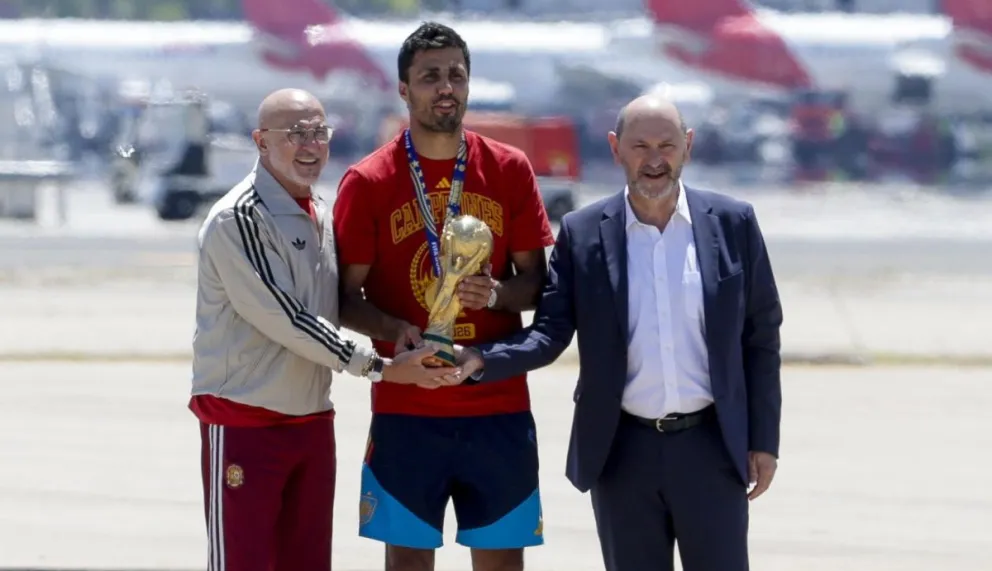 Luis de la Fuente (izq.), Rodri y Rafael Louzán Abal, presidente de la RFRF, con el trofeo en el aeropuerto de Barajas. Foto: EFE