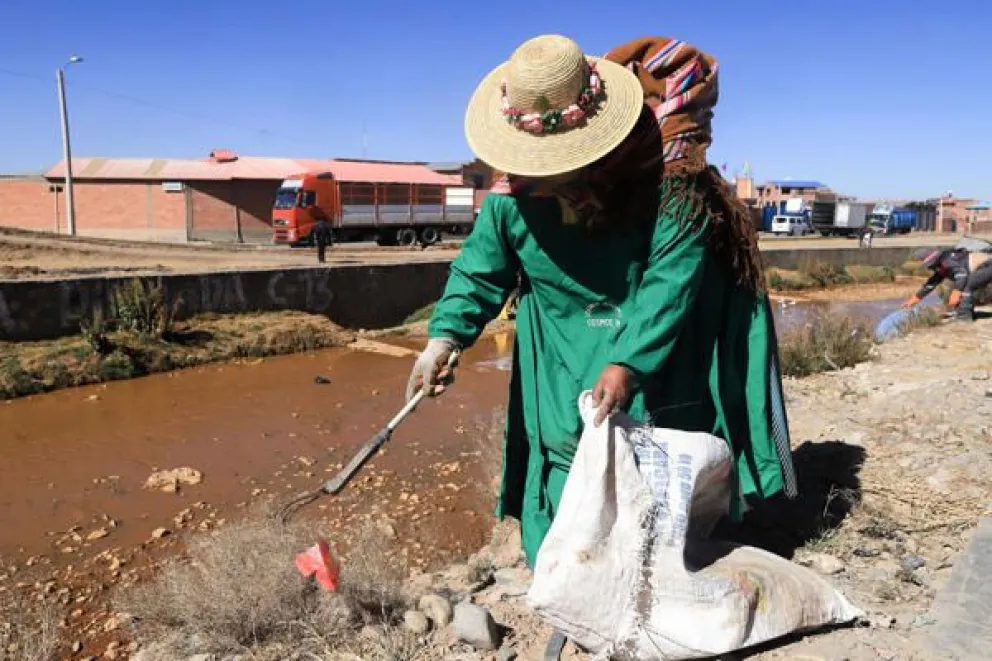 Una mujer aimara participa en una jornada de limpieza del río Seke, contaminado por basura y otros desechos que desembocan en el lago Titicaca, este sábado en El Alto (Bolivia). Foto:EFE