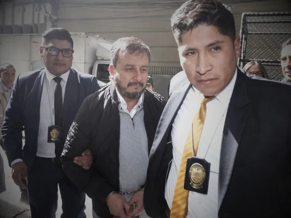 El exministro Mauricio Medinaceli enmanillado es llevado por dos policías hasta la Fiscalía. Foto: APG