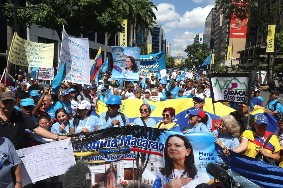 Personas sostienen carteles este martes, durante una manifestación en Caracas (Venezuela). Foto: EFE
