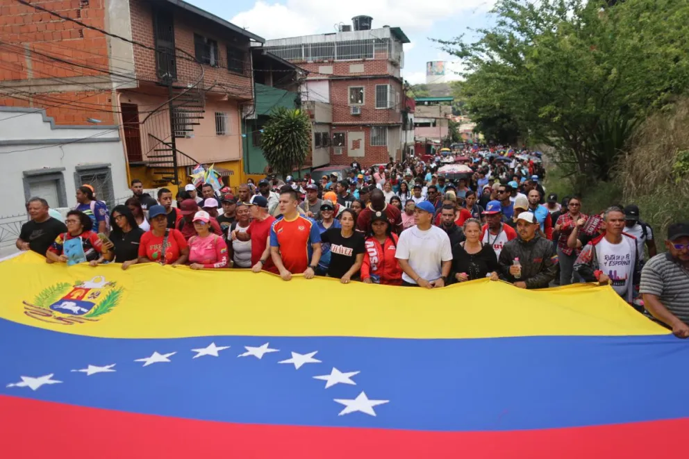 Personas participan este martes en una marcha para conmemorar el natalicio del presidente venezolano fallecido Hugo Chávez. Foto: EFE/