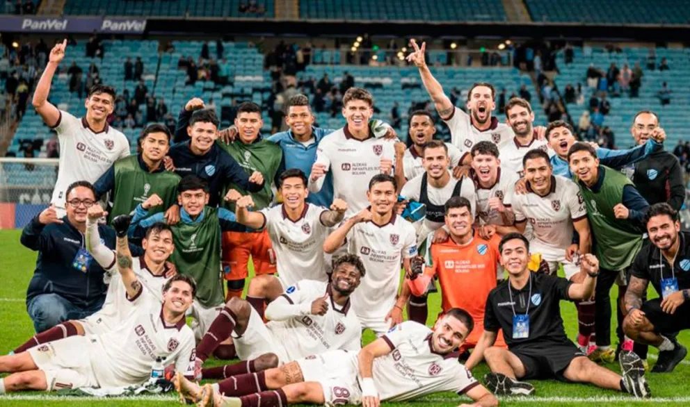 Jugadores, cuerpo técnico y dirigentes de Bolívar celebran la clasificación en el campo de juego del Arena do Gremio. Foto: Club Bolívar