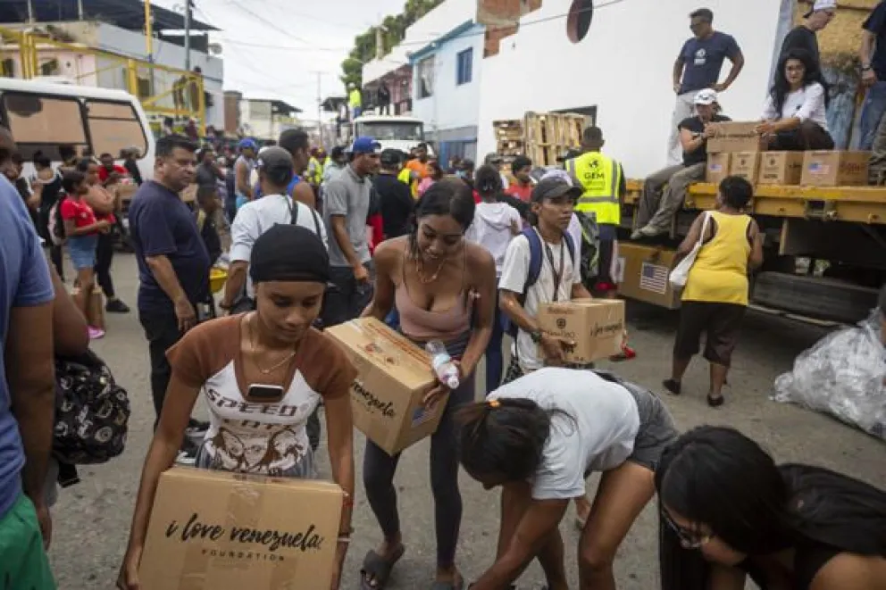 Personas reciben ayuda humanitaria en Caraballeda (Venezuela). EFE