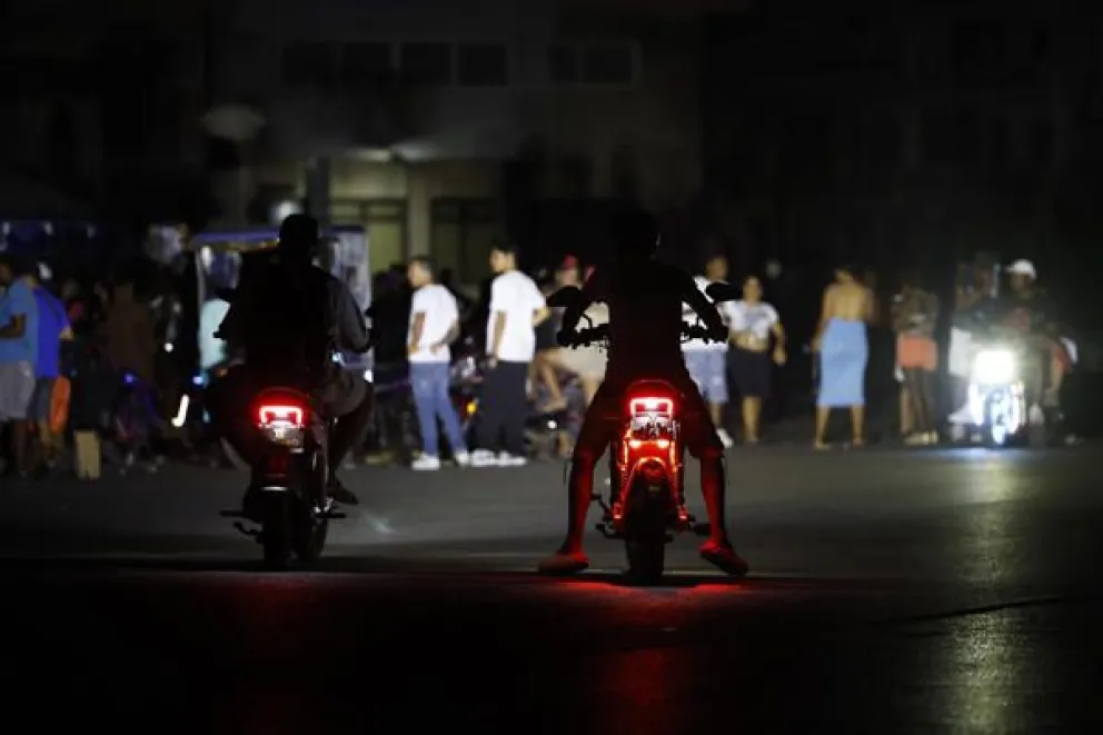 Personas en motocicleta transitan por un calle durante un apagón este sábado, en La Habana (Cuba). EFE