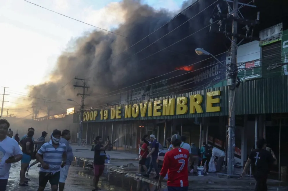 El incendio en la Feria Barrio Lindo, en la ciudad de Santa Cruz, es combatido por la Unidad de Bomberos. Foto APG