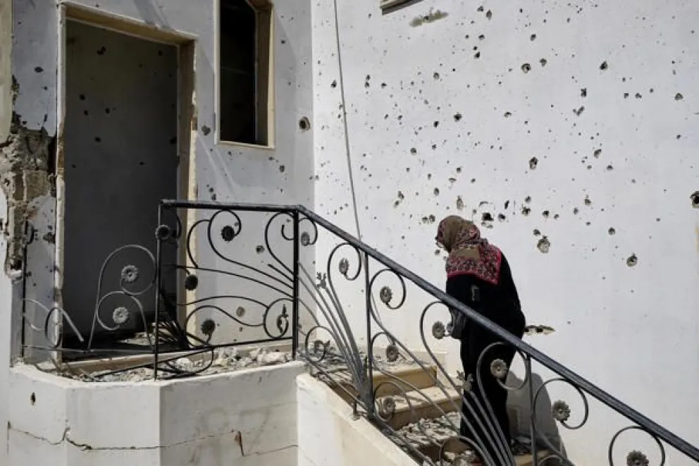 Ihsan Yaghi, de 60 años y vecina de la localidad de Zawtar al Gharbiya, entra en su vivienda tras el paso del ejército israelí por la localidad de Zawtar Al Gharbiya, al sur del Líbano. Foto EFE