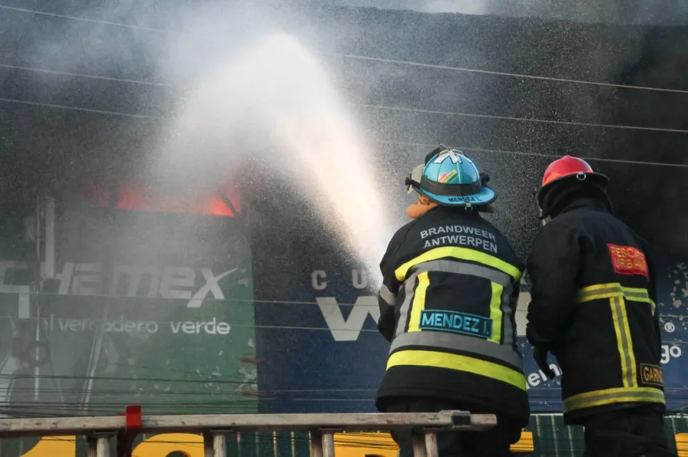 Bomberos combatiendo el fuego en la feria Barrio Lindo. Foto: APG