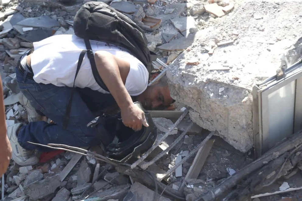 Un hombre fue captado este 10 de agosto al buscar entre los escombros de un edificio colapsado en Cali (Colombia), luego del fuerte terremoto de magnitud 7,4 que sacudió a buena parte del país suramericano. EFE