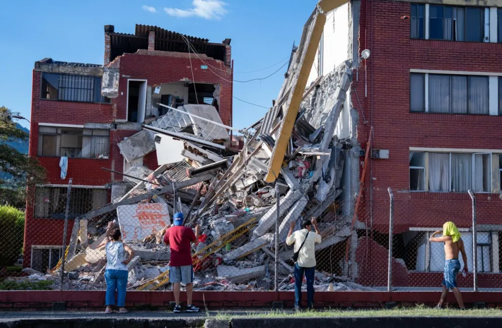 Personas observan viviendas afectadas luego de un terremoto de magnitud 7,4 este lunes, en Pereira (Colombia). EFE