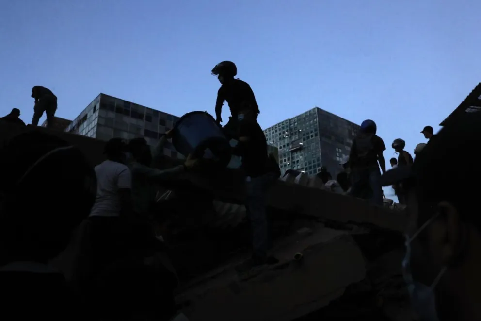 Personas trabajan en labores de rescate en una edificación colapsada por el terremoto de magnitud 7,4 que sacudió al país este lunes, en Cali (Colombia). Foto: EFE