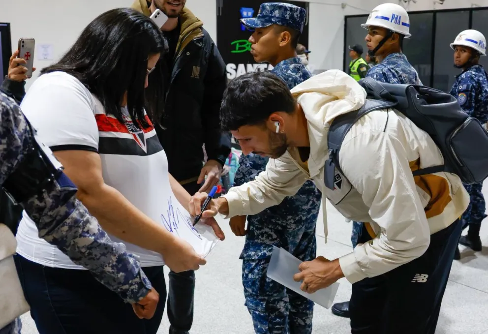 Un jugador del Sao Paulo firma la camiseta de una hincha en el aeropuerto de Santa Cruz. Foto: CSP