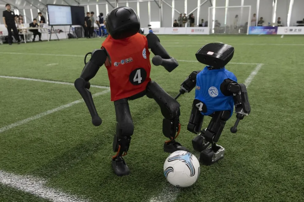 Dos robos juegan al fútbol. Foto: EFE.