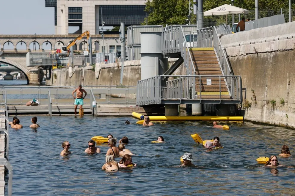 Varias personas nadan junto a las orillas del río Sena, en la zona de baño de Bercy, durante una ola de calor en París, Francia. Foto: EFE