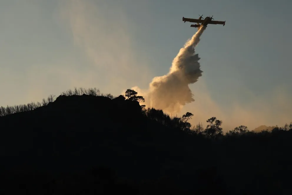 Un avión de extinción de incendios opera para sofocar un incendio forestal en la isla de Salamina, Grecia. EFE/EPA/GEORGE VITSARAS