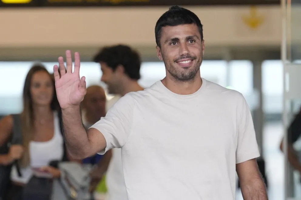 El centrocampista español Rodrigo Hernández 'Rodri' saluda a los hinchas en el aeropuerto de Barcelona. Foto: EFE