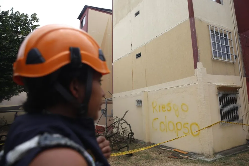 Una integrante de organismos de socorro observa los edificios Chiminangos, los cuales presentan fallas estructurales y riesgo de colapso tras el terremoto de magnitud 7,4 ocurrido hace una semana en Cali (Colombia). Foto: EFE
