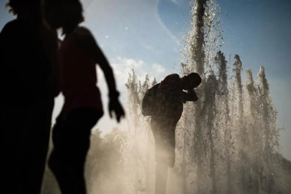 Imagen de archivo de un grupo de personas refrescándose en una fuente en Berlín. EFE/ Clemens Bilan