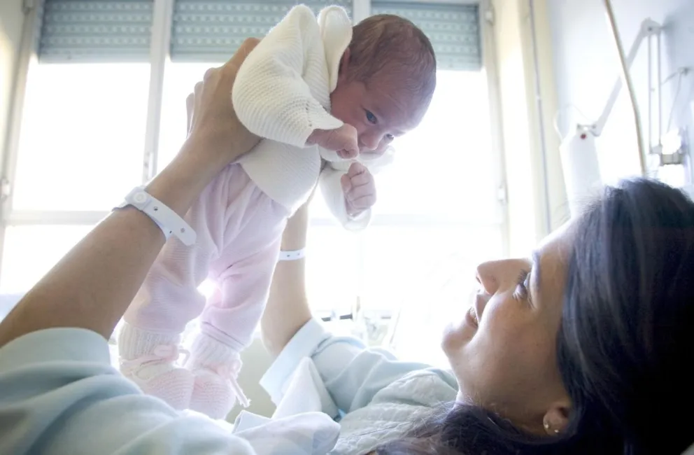Fotografía de archivo en la que se captó a una bebe recién nacida al ser alzada en brazos por su madre. Foto: EFE